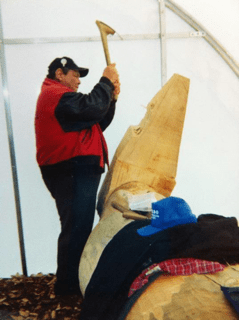 Man carving a totem pole