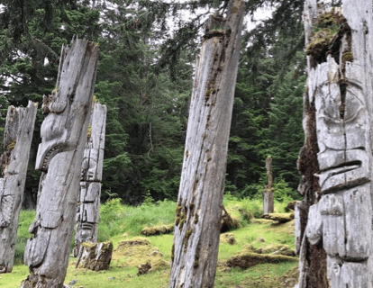 Poteaux totémiques debout dans une forêt.