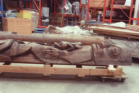 Portion of a totem pole laying on its side in carving studio