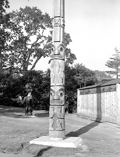 View of the bottom half of the memorial pole standing in Thunderbird Park.