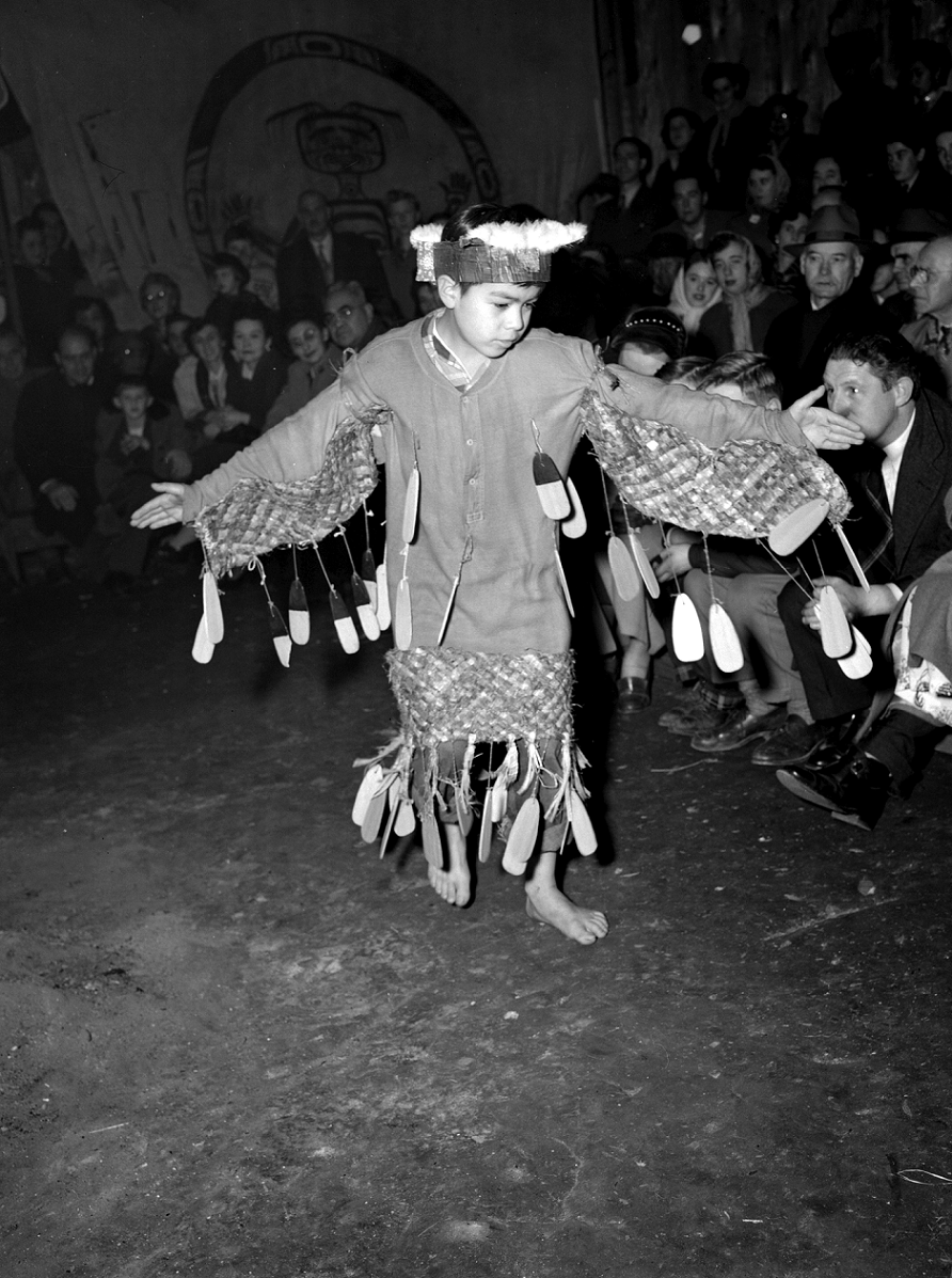 Young boy in regalia dancing.