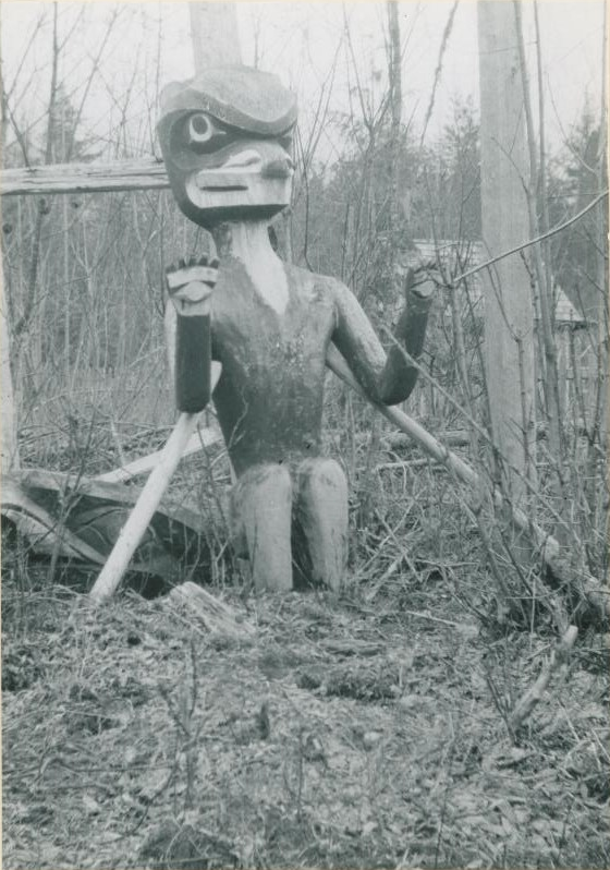 Figure sculptée d’un ours debout dans la broussaille.