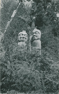 Face-on view of two house posts standing in foliage.