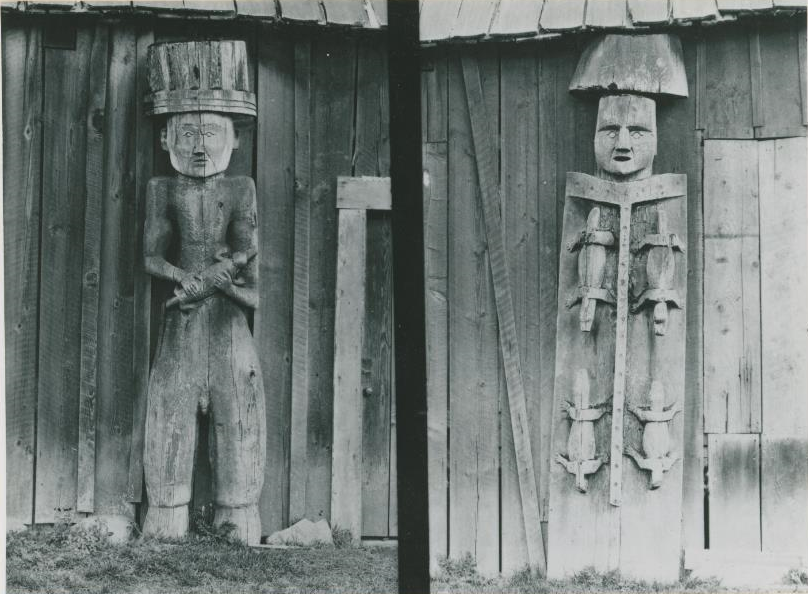 Detailed view of five house posts against the side of a building.