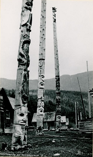 Three carved poles standing at their village site.