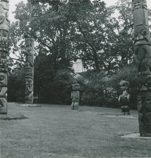 Figure d’ours sculptée dans le Parc Thunderbird parmi d’autres figures sculptées et des poteaux. 