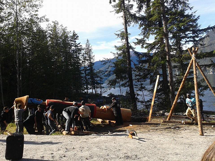 Groupe d'hommes dressant un totem.