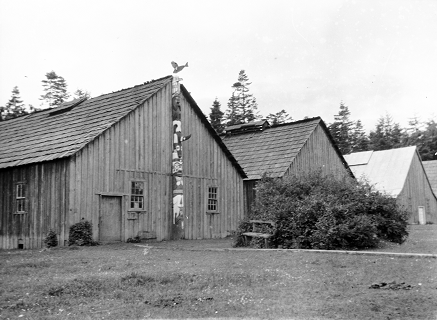 Poteau de maison devant trois maisons.