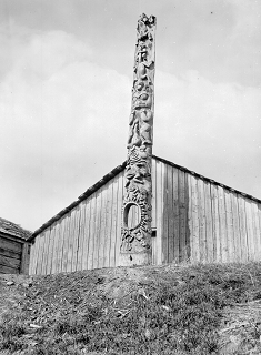 Totem pole stands in front of house