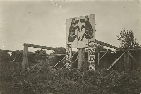 Carvings and sign in front of a fence