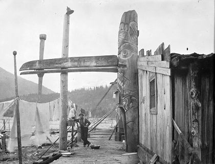 Homme debout à côté du poteau d'entrée à côté de la maison.