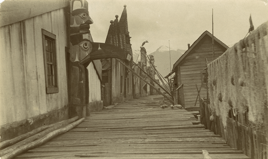 Boardwalk surrounded by totems placed in front of each house