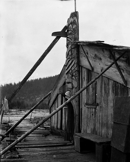 Totem pole braced in front of entrance of house